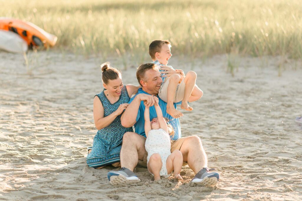 Playful family tickling during golden hour beach session at drake's island beach in wells maine by carrie pellerin