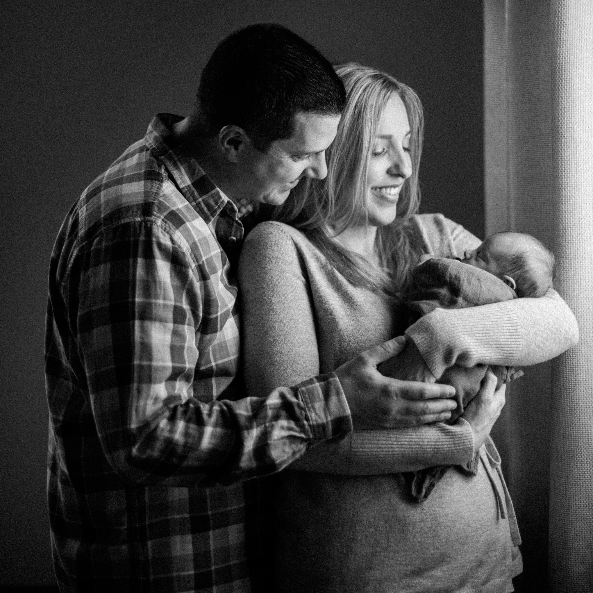 Mother and Father holding newborn son in black and white family photos