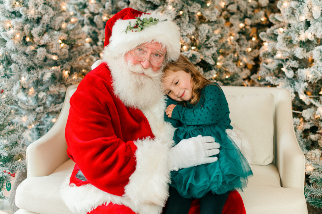 Little girl snuggling santa