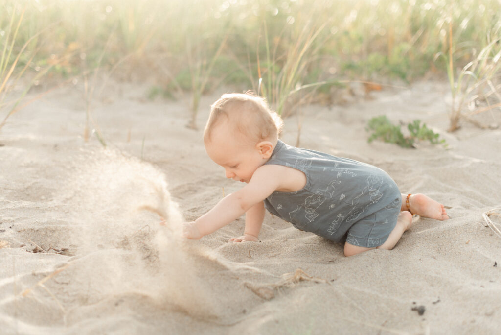 One year old crawling on beach