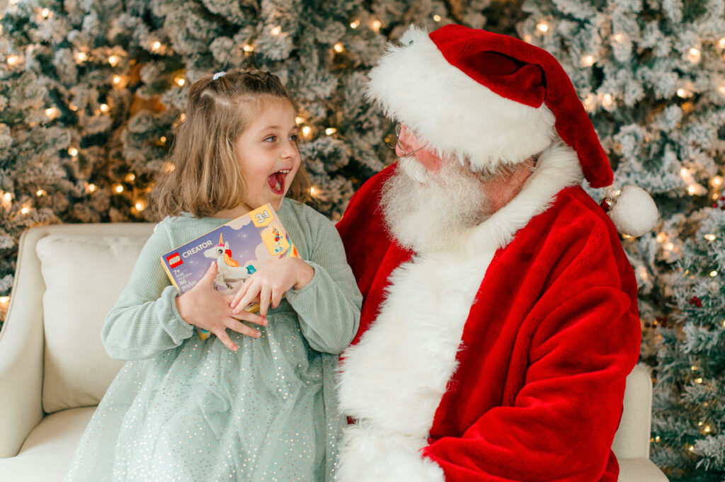 Little girl very excited to open gift from Santa