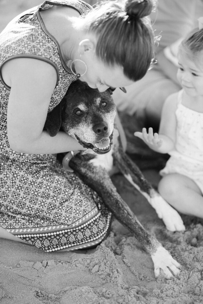 mother kissing family pup during maine family session