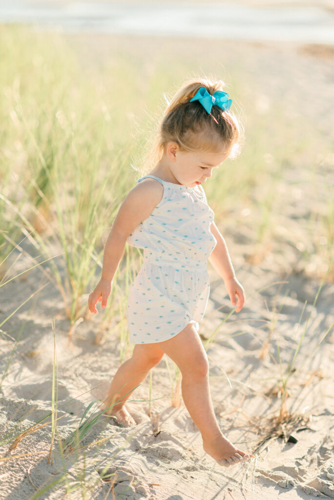 little girl walking near the dunes of Drakes Island Beach in Maine